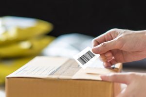 hand holding barcode label on shipping box box with barcode